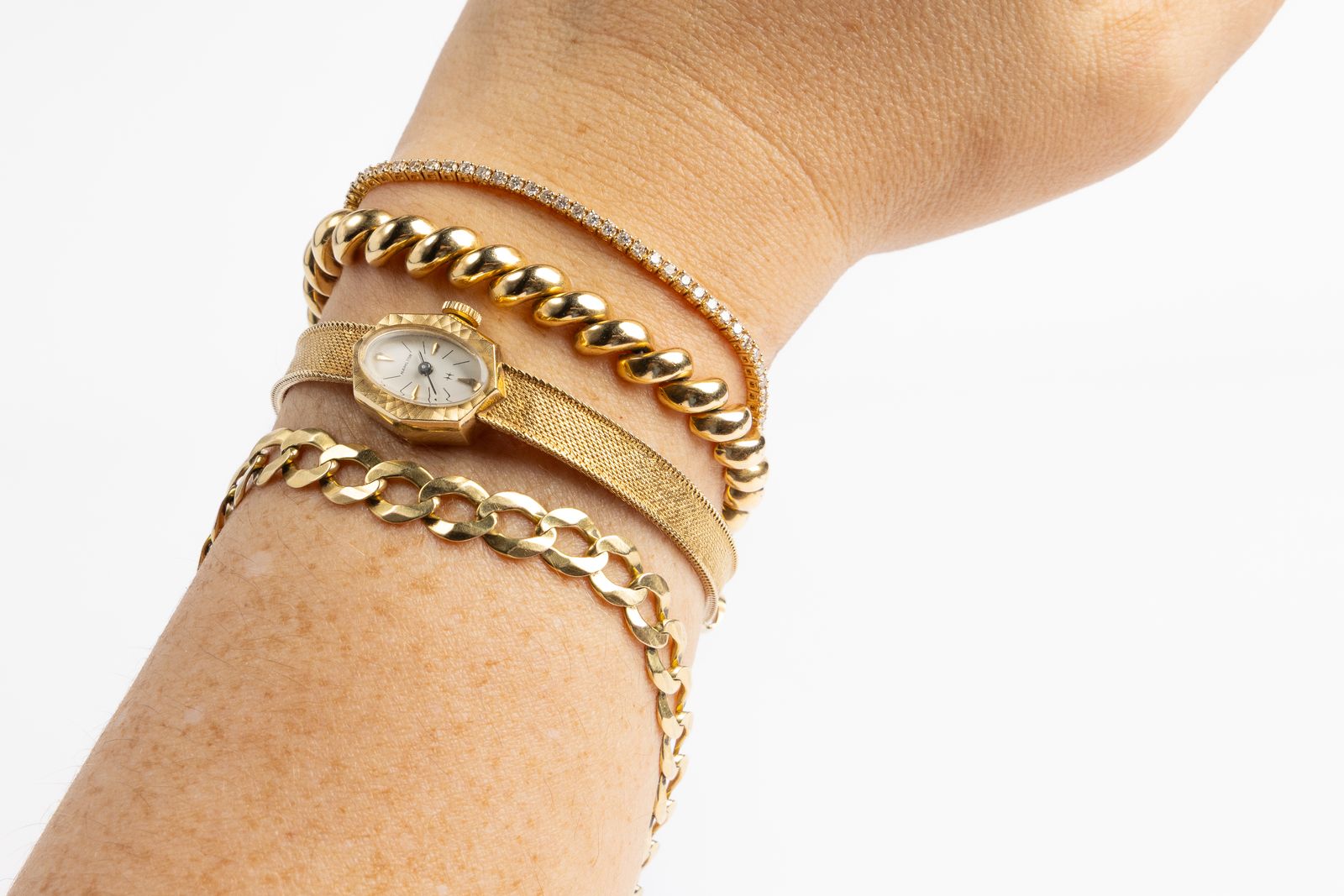 Layered gold necklaces worn by a client during a private jewelry evaluation